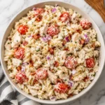 Chicken Ranch Pasta Salad with creamy ranch, tomatoes, bacon, chicken, and red onion in a white bowl