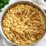 Creamy Chicken Pasta with golden chicken and shells in a bubbling sauce in a skillet