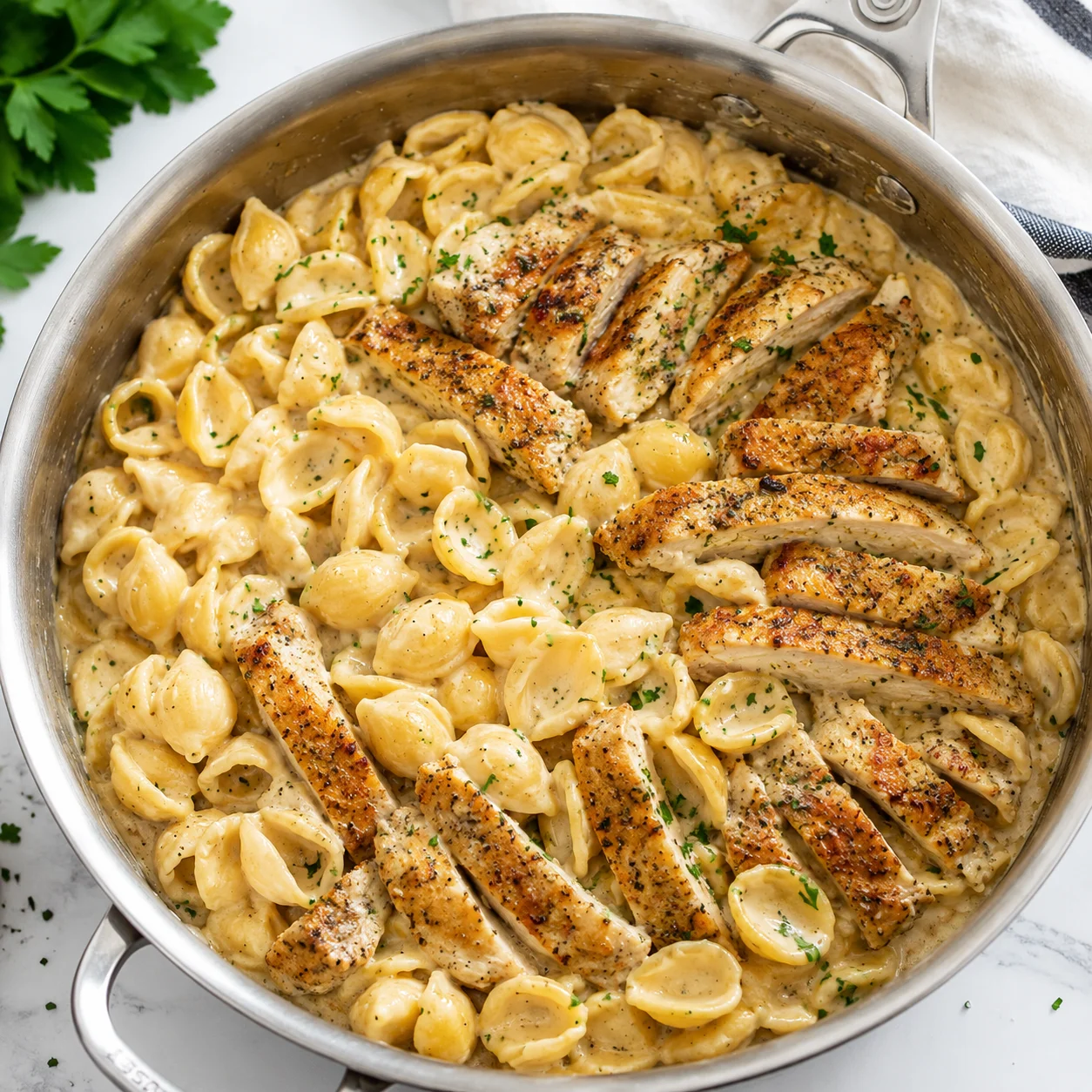 Creamy Chicken Pasta with golden chicken and shells in a bubbling sauce in a skillet