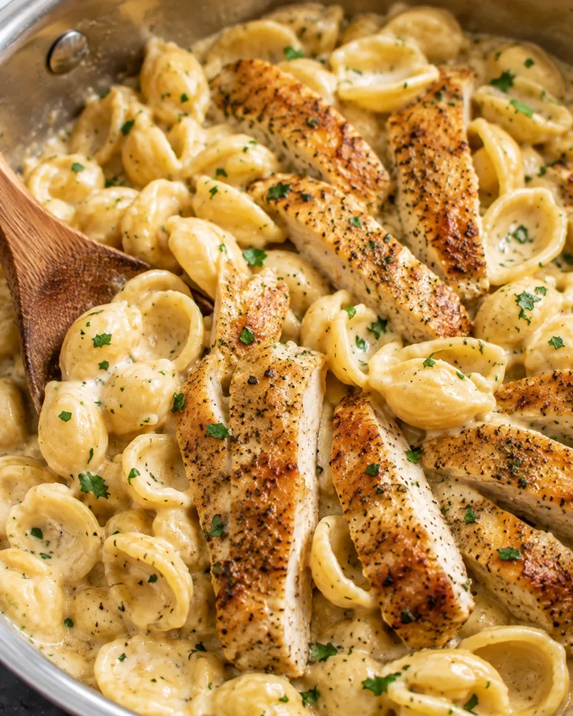 Creamy Chicken Pasta with golden chicken and shells in a bubbling sauce in a skillet
