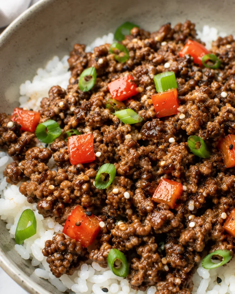 Easy Beef Rice Bowls with saucy beef, red bell pepper, and sesame seeds over fluffy rice